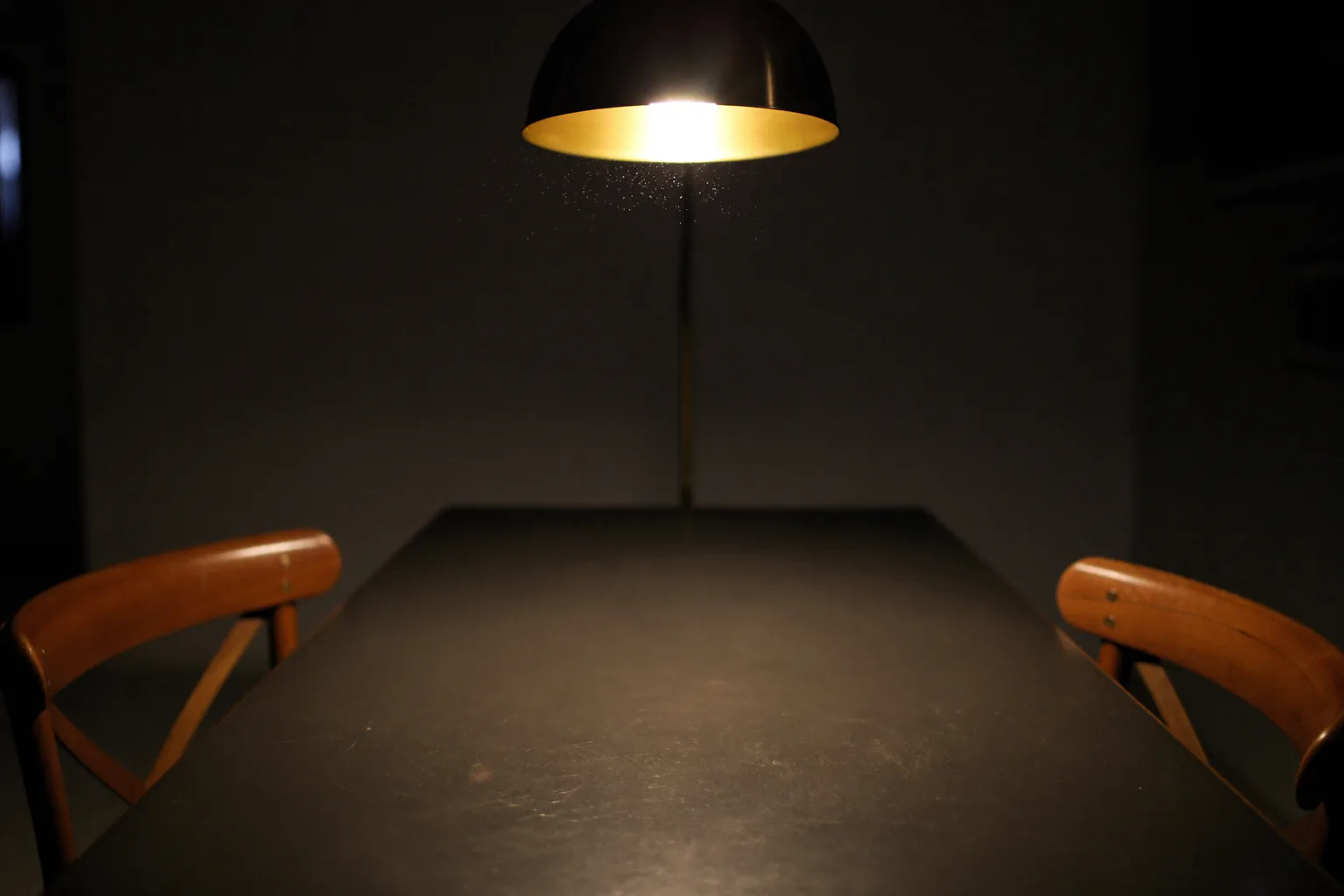 Two empty chairs facing each other across a table under a gold lamp, representing misdemeanor battery in Nevada